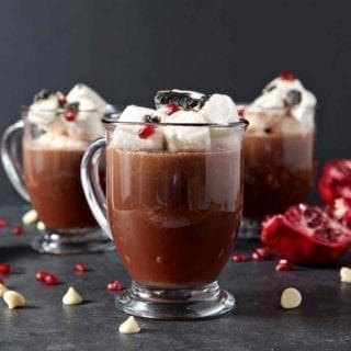 3 pomegranate white hot chocolates in glasses with marshmallows