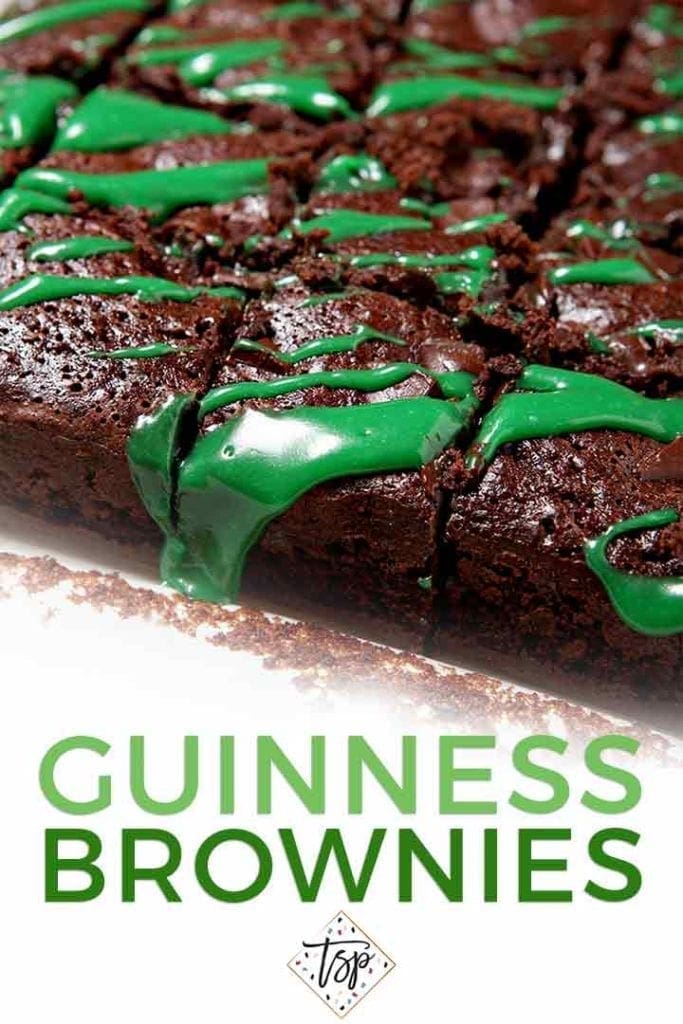 Close up of sliced brownies drizzled with green frosting in a pan with the text 'guinness brownies'