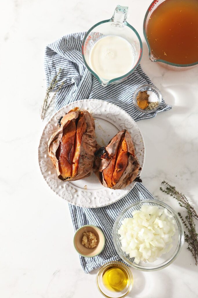 Roasted sweet potatoes and other ingredients sit on a blue striped towel on a marble countertop