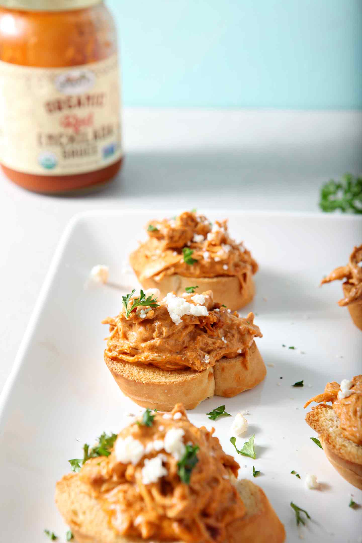 Chicken Enchilada Bruschetta lined up on a white platter before serving