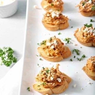 Chicken Enchilada Bruschetta lined up on a white platter before serving