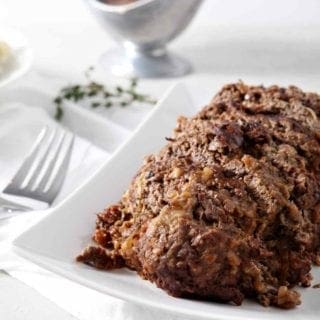 French Onion Meatloaf, sitting on a white platter, sliced and ready for eating