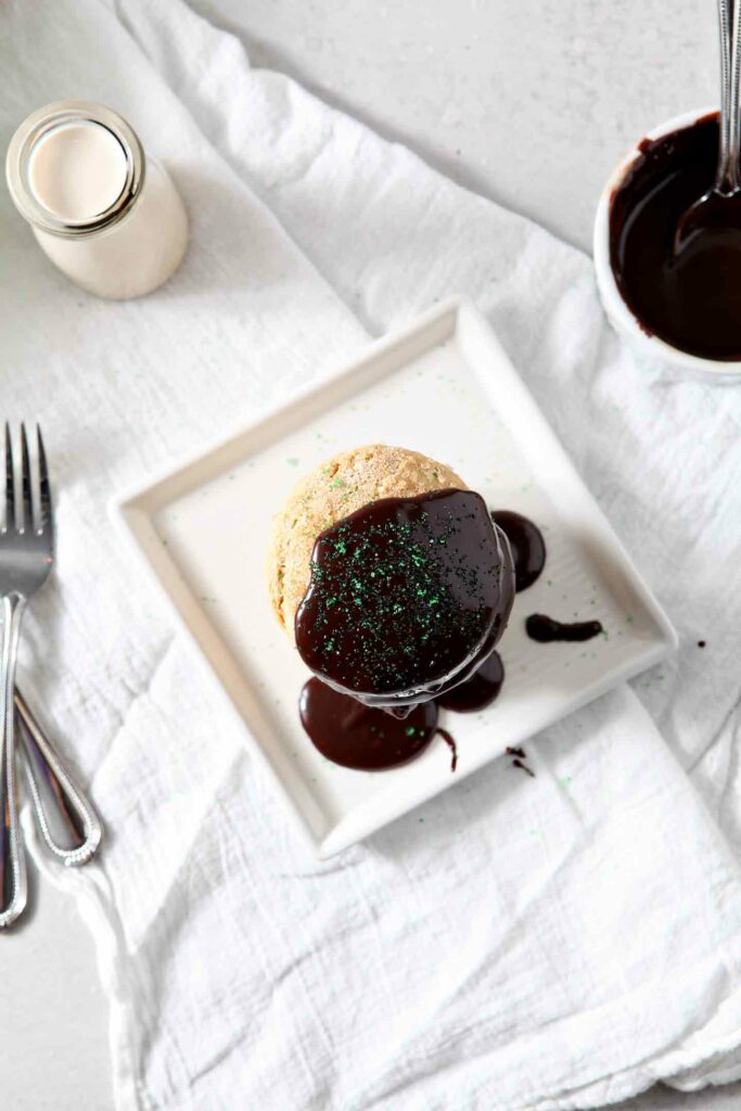 Irish Cream Biscuits stacked on top of each other and drizzled with Boozy Chocolate Ganache on a white background