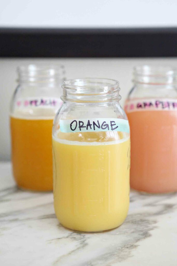 Juices, served in mason jars and labeled with washi tape, are set out for guests