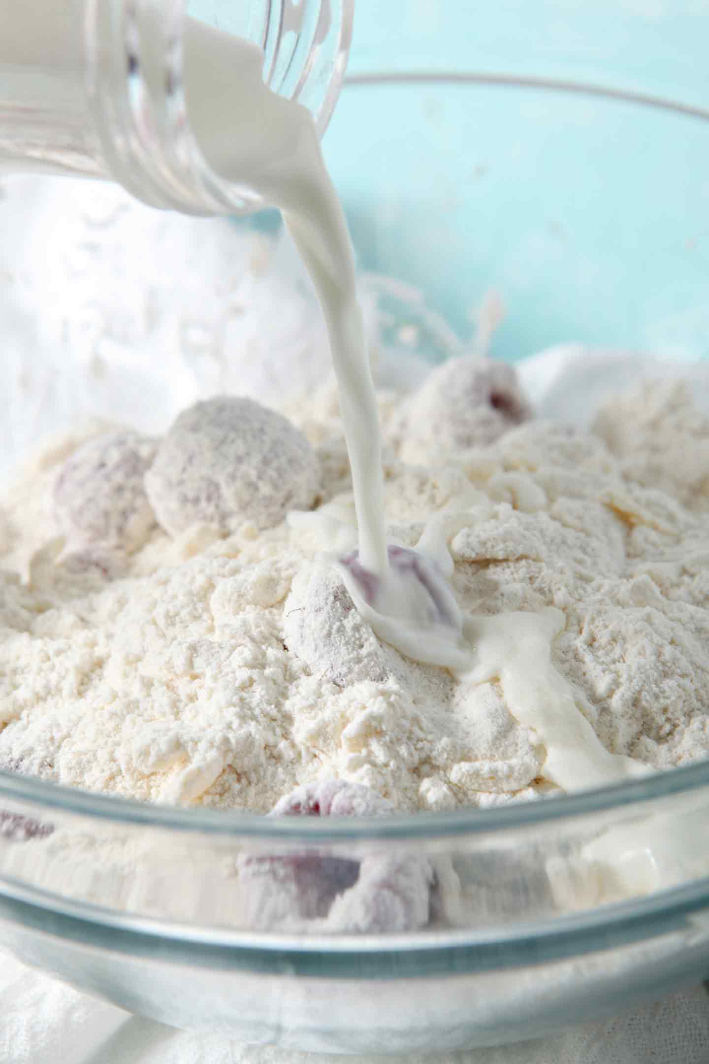 Milk being poured into Raspberry Shortcake Biscuit batter before the ingredients are finally mixed together and the biscuits are formed.