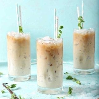 Three Dunkin' Donuts Cold Brew with Homemade Vanilla Mint Creamer, on a turquoise background, ready for drinking