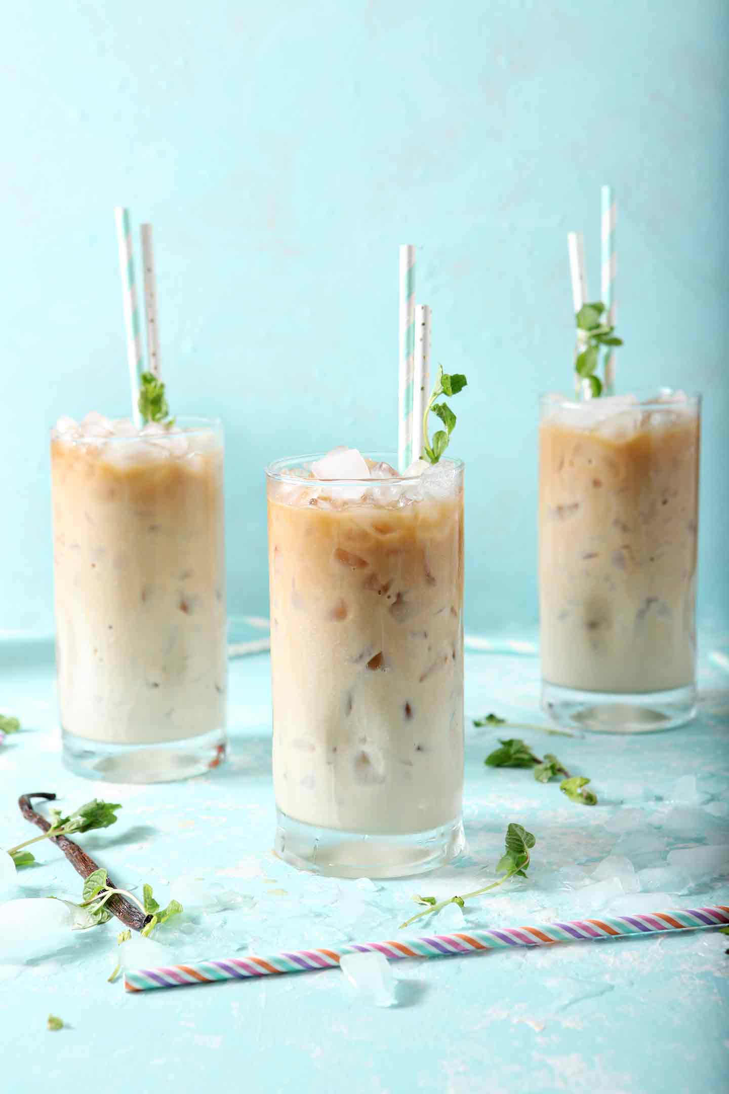 Three Dunkin' Donuts Cold Brew with Homemade Vanilla Mint Creamer, on a turquoise background, ready for drinking