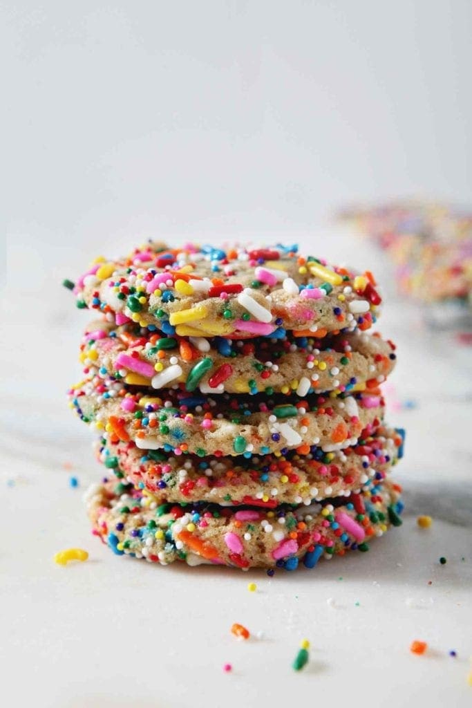 A stack of Funfetti Cookies sits on a marble background