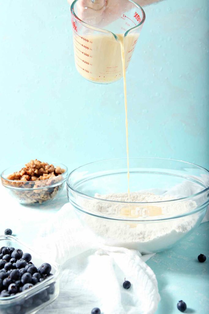 Liquid pours into dry ingredients for homemade pancakes