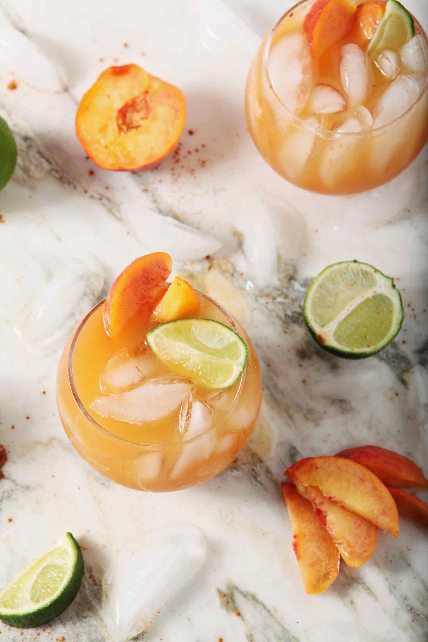 Overhead image of two Peach Moscow Mules, garnished with peach slices and lime wedges