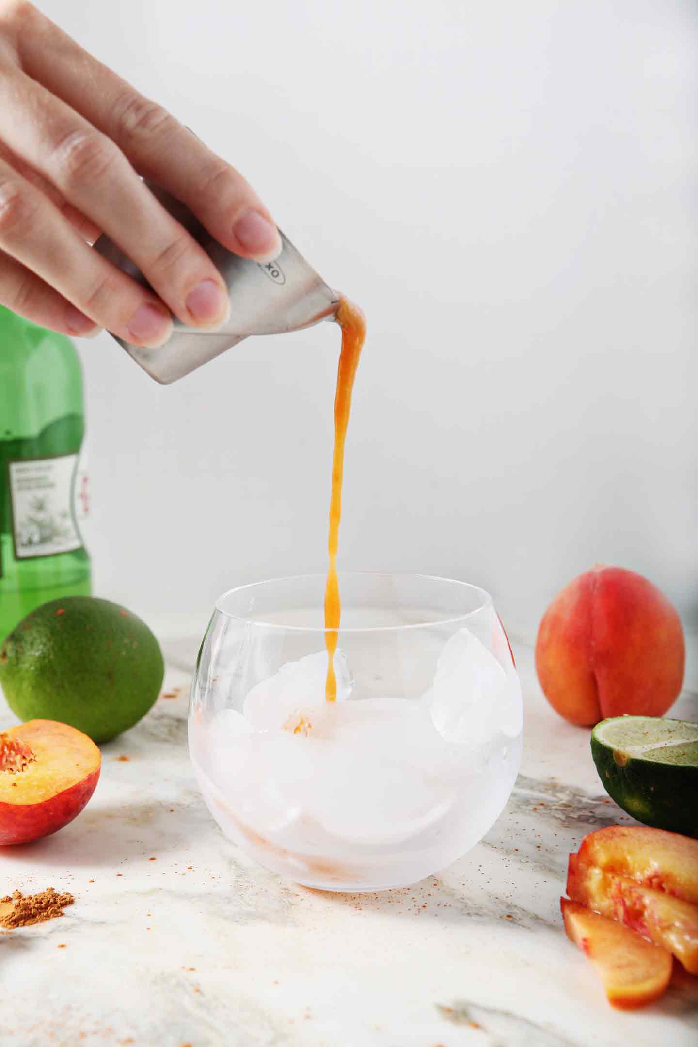 Peach puree is poured into a glass, from the side