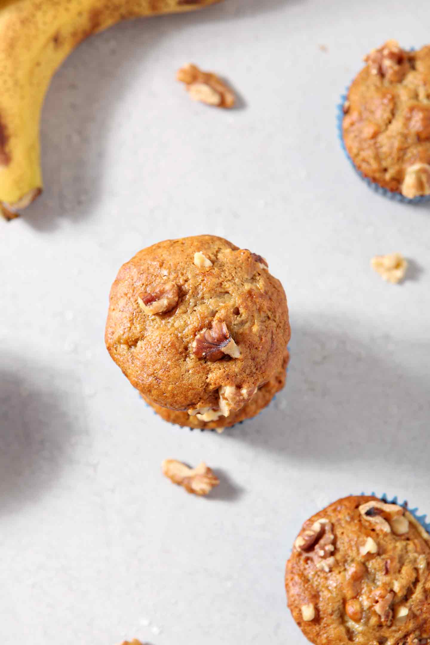 Overhead image of Vegan Banana Muffins, shown with walnuts and bananas