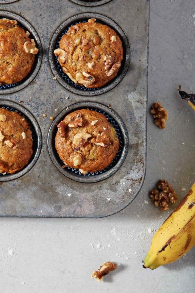 Vegan Banana Muffins sit in the muffin tin after coming out of the oven