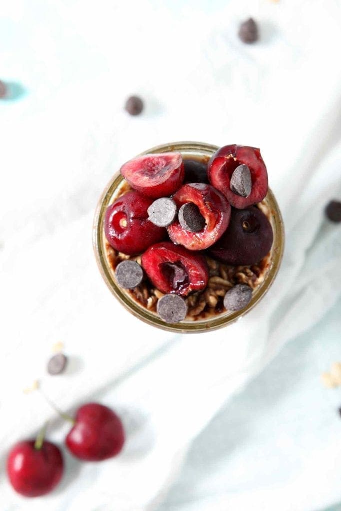 Close up of Cherry Overnight Oats from above, highlighting the fresh cherries and chocolate chips used as toppings