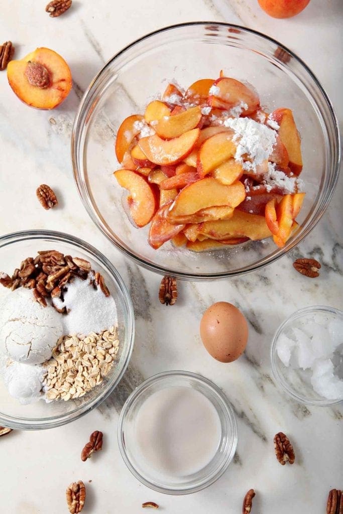 All the ingredients for Dairy Free Peach Cobbler are laid out on a marble counder