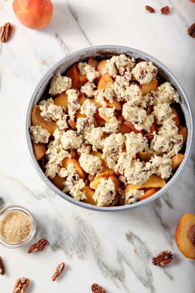 Dairy Free Peach Cobbler is shown from above, just before going into the oven