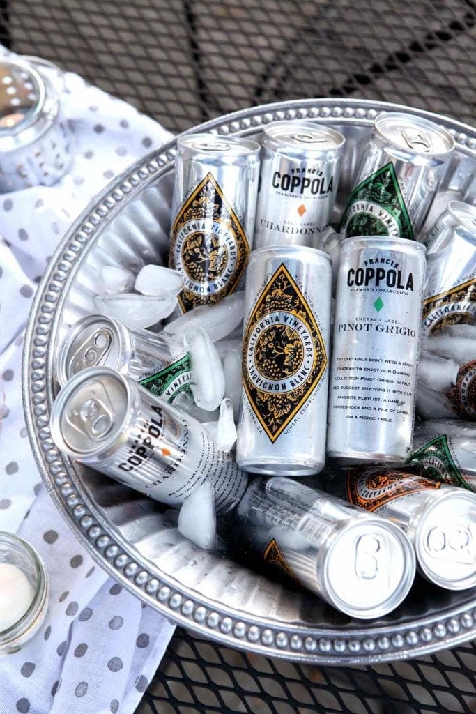 Coppola Diamond Collection cans sit in a silver ice bucket at an outdoor gathering