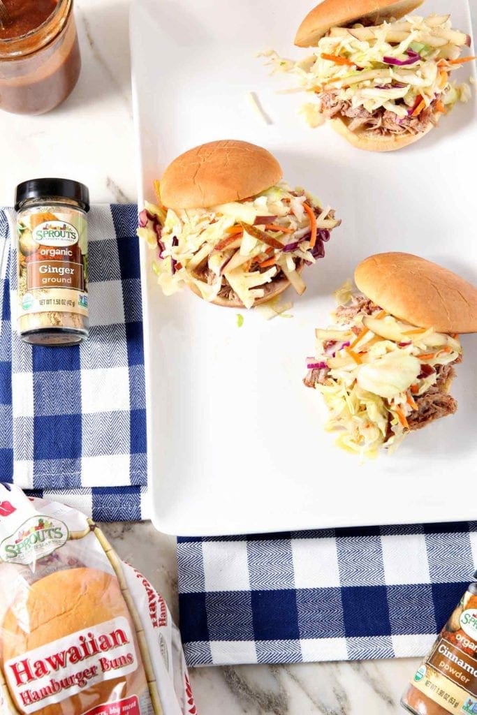 Three Pear BBQ Pulled Pork Sandwiches with Pear Slaw are shown from above on a white platter