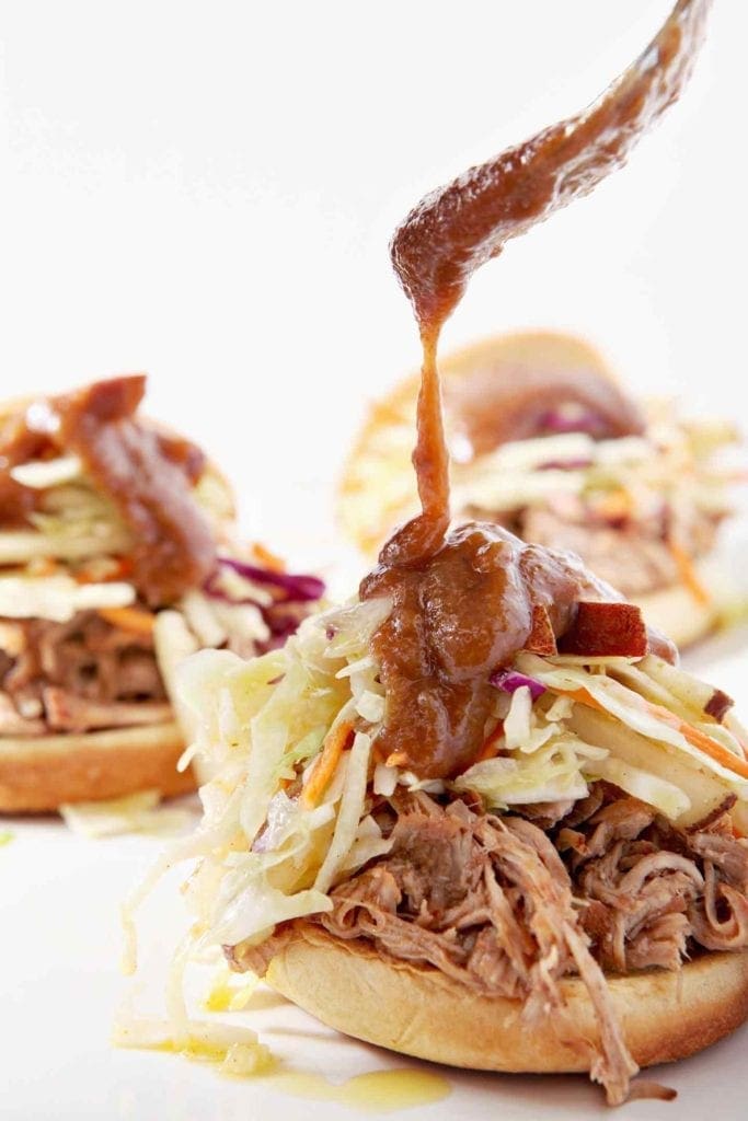 Pear BBQ Sauce is drizzled onto Pear BBQ Pulled Pork Sandwiches with Pear Slaw.