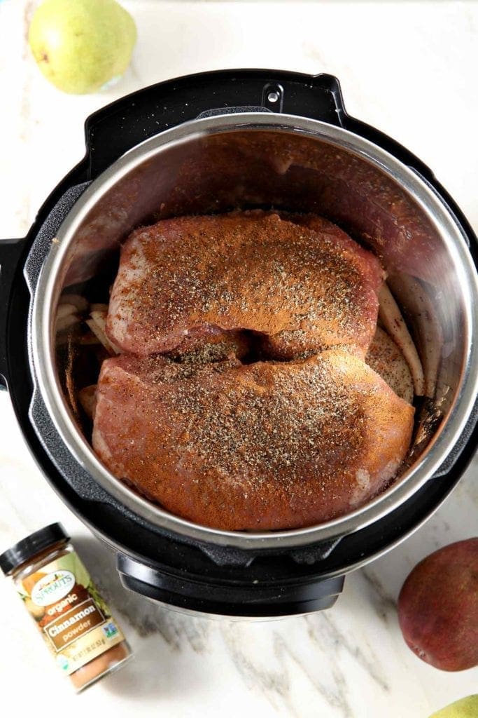 Pork sirloin roasts are shown in the base of an Instant Pot before cooking