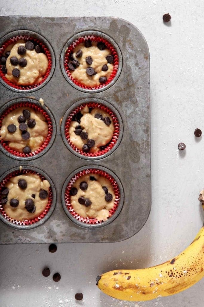 Vegan Banana Chocolate Chip Muffins sit in a muffin tin before baking.