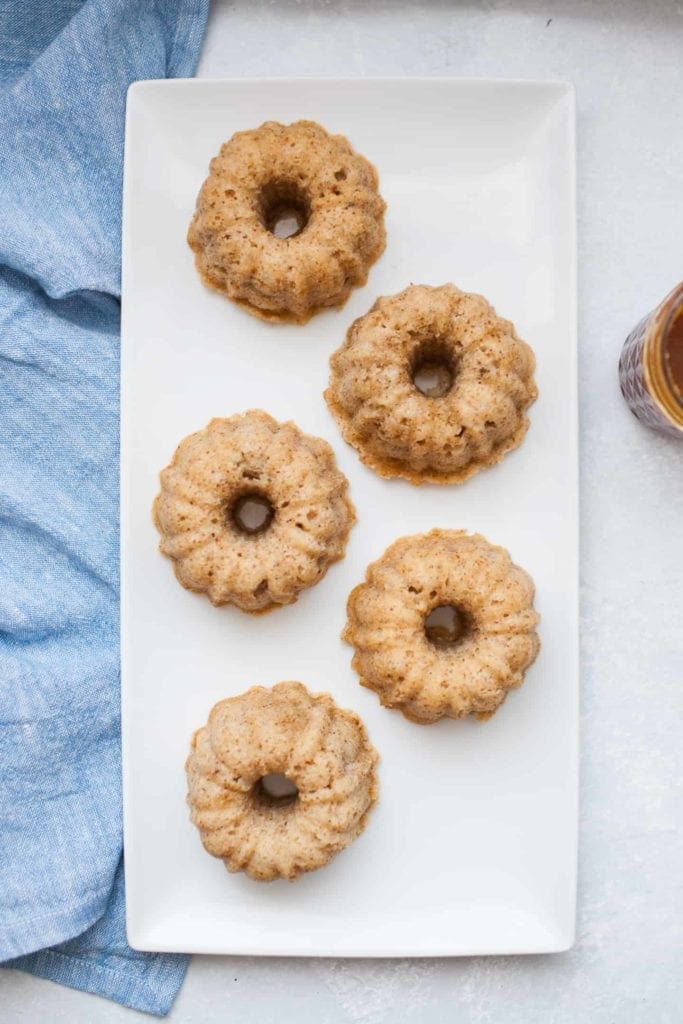 mini apple spice bundt cakes on a rectangular white serving board