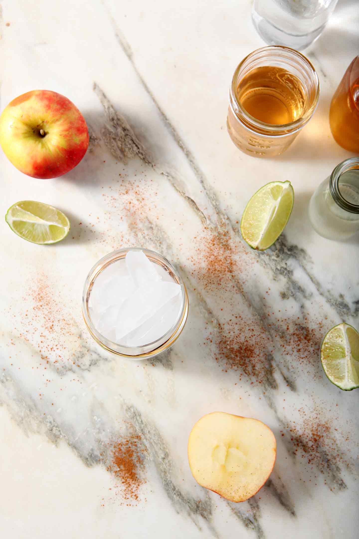 Ingredients for a cider Moscow Mule lined up on marble