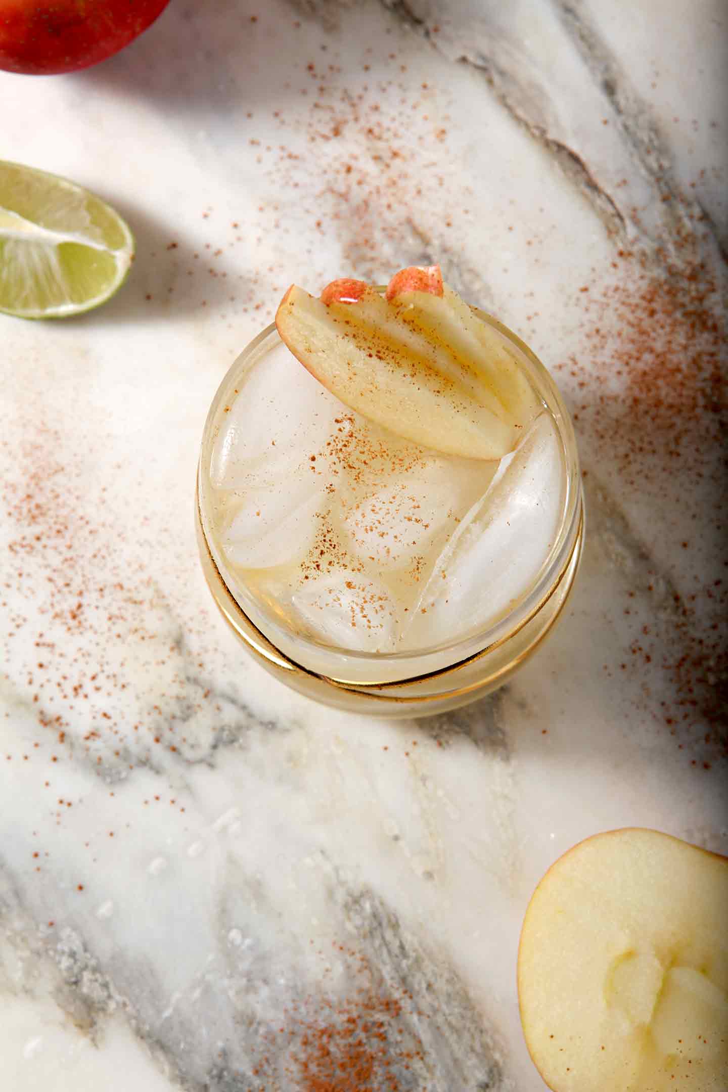 Overhead image of an Apple Cider Moscow Mule, shown with apples and lime slices