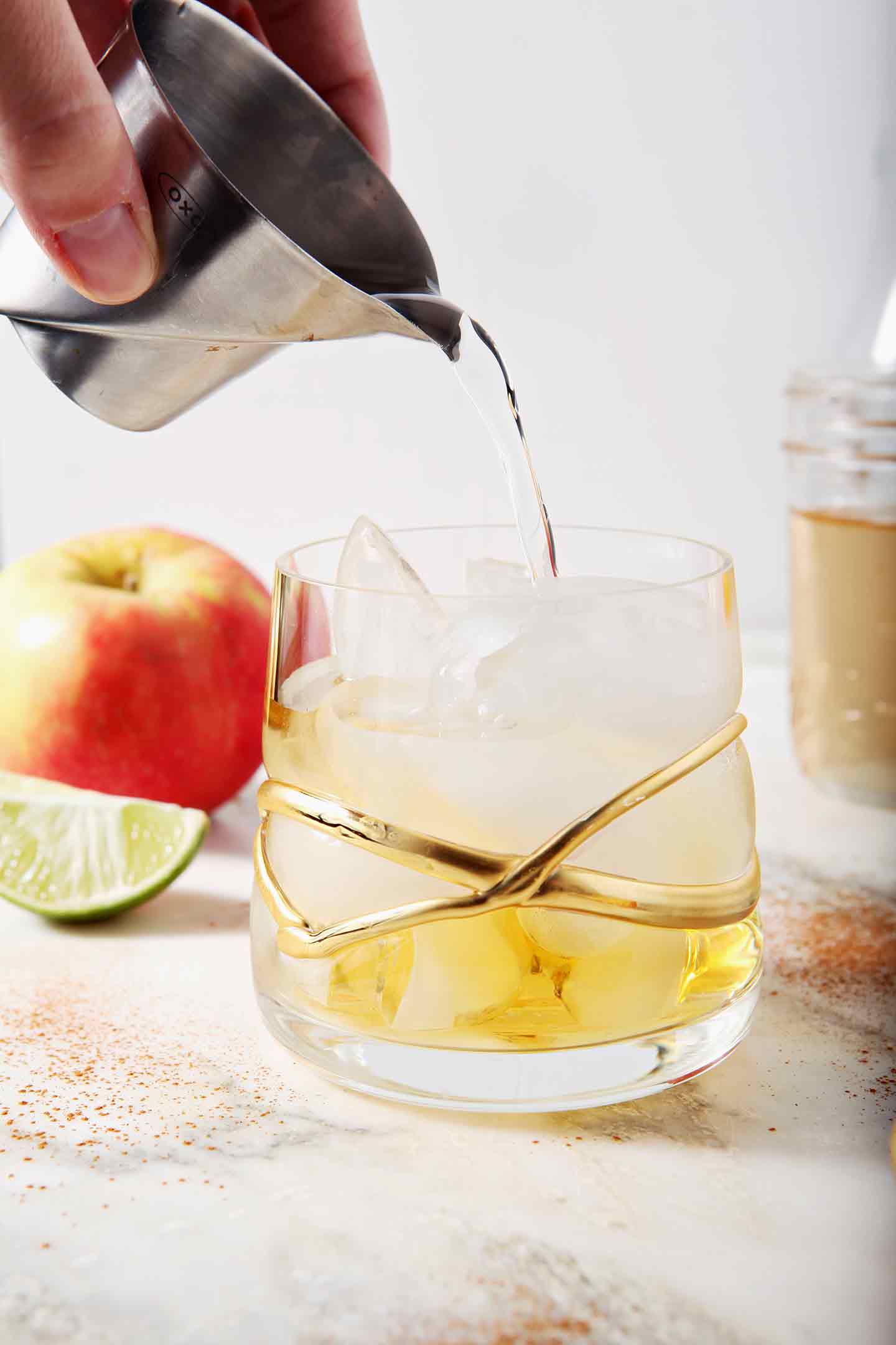 Cinnamon simple syrup is pours into a glass with apple cider