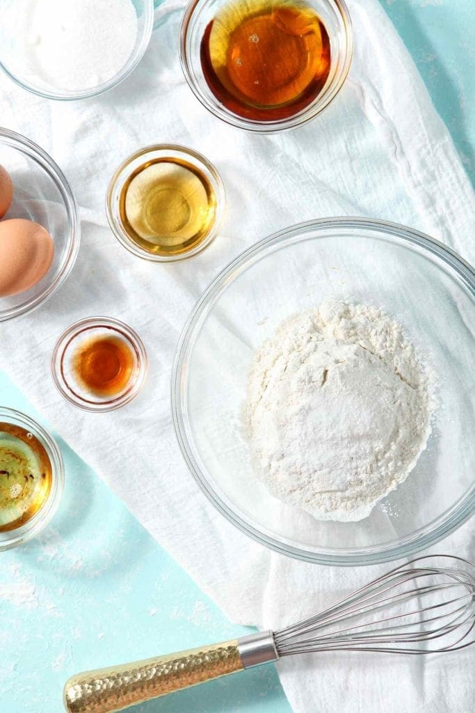 Ingredients for Bourbon Maple Bacon Cupcakes are laid out on an aqua background