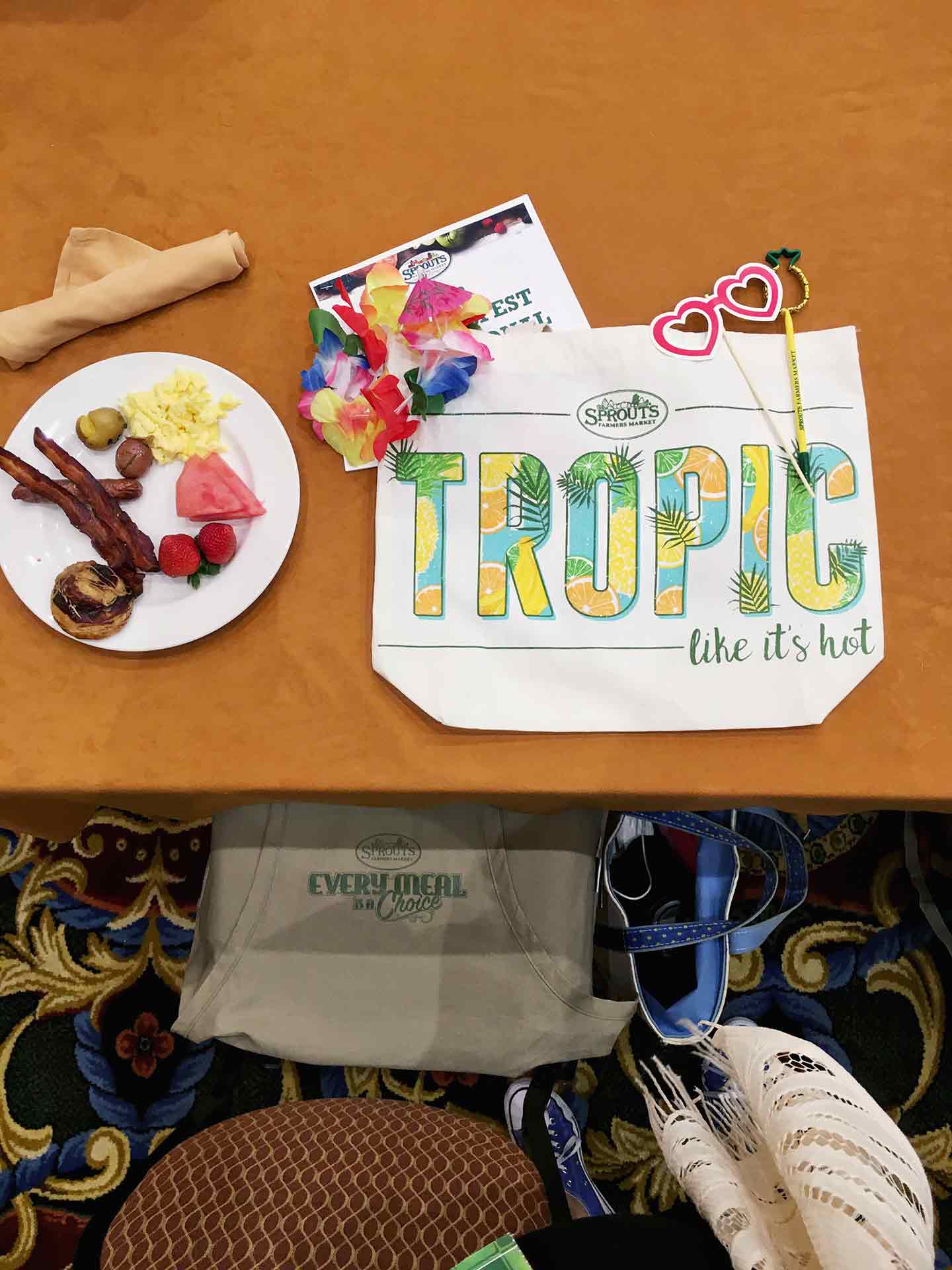 A canvas reusable bag sits on a table with breakfast at SproutsFest