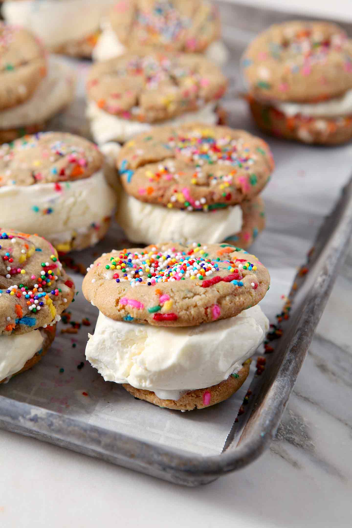 Funfetti Ice Cream Sandwiches sit on a baking sheet, lined with wax paper, before going into the freezer