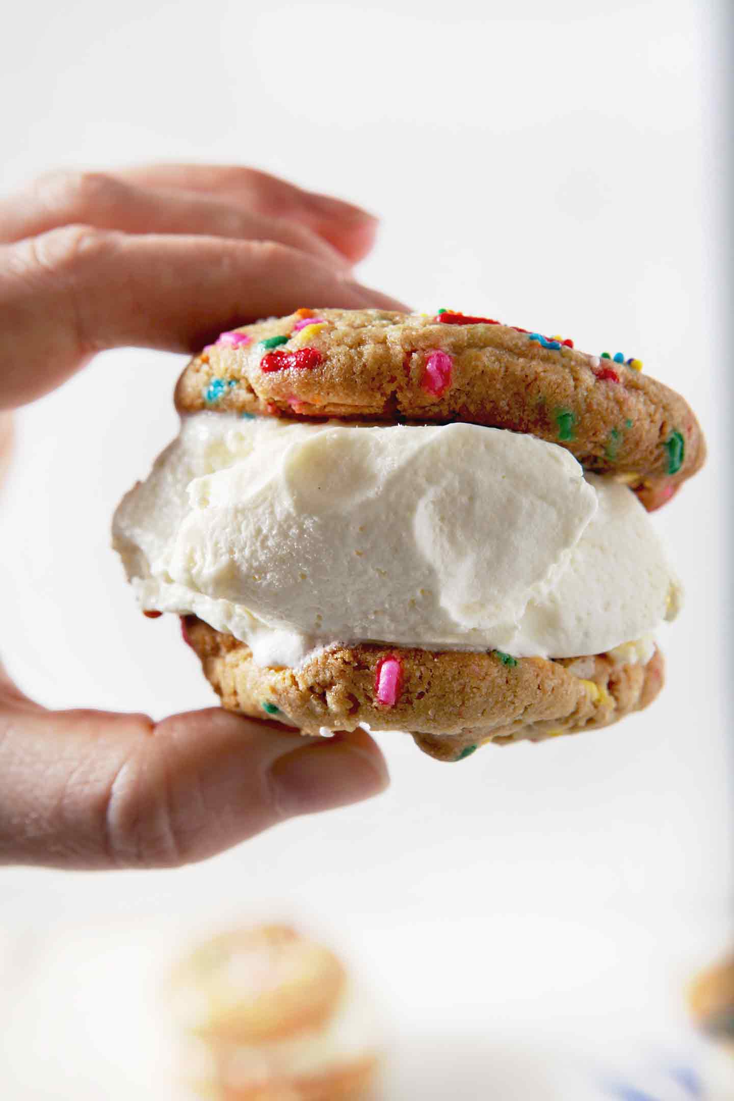 A woman holds a Funfetti Ice Cream Sandwich before biting into it