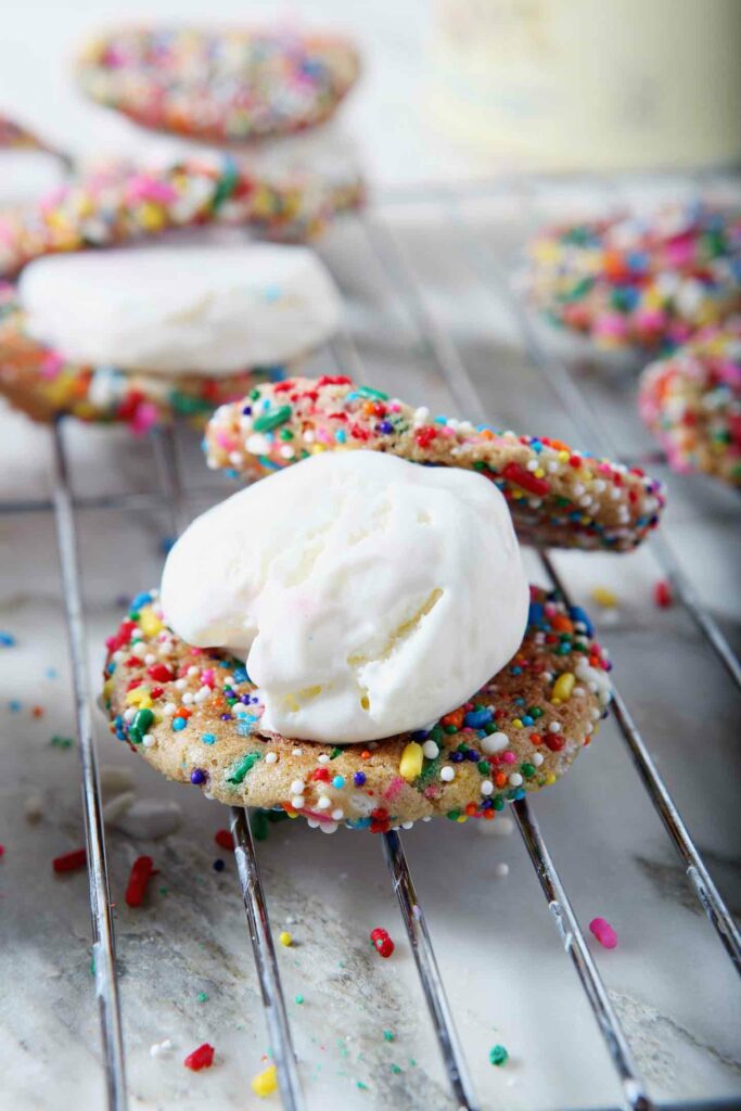 A scoop of ice cream sits on a Funfetti Cookie before it is turned into an Funfetti Ice Cream Sandwich