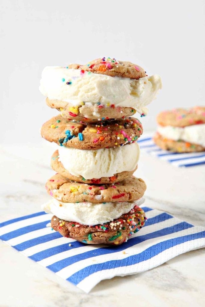 Three Funfetti Ice Cream Sandwiches are stacked on top of each other on a blue-and-white striped napkin