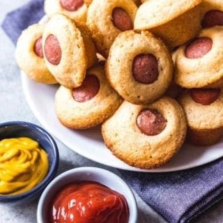 Corn Dog Mini Muffins are served on a plate with ketchup and mustard for dipping