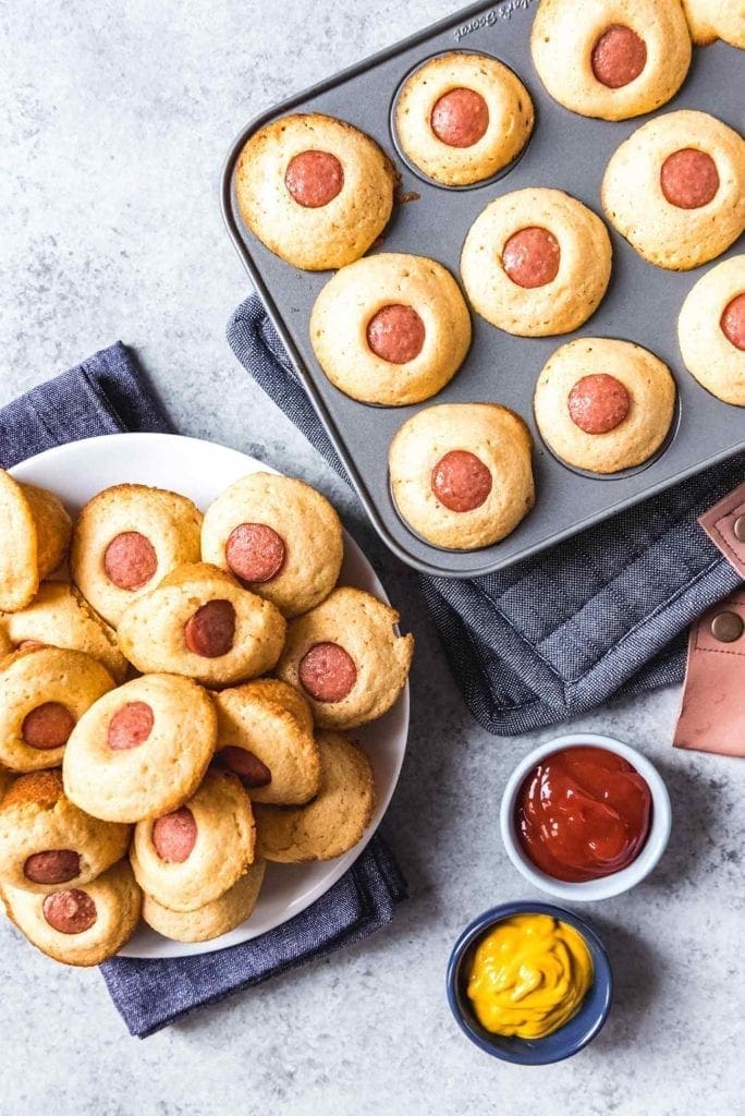 Overhead image of Corn Dog Mini Muffins on a plate and in the mini muffin tin