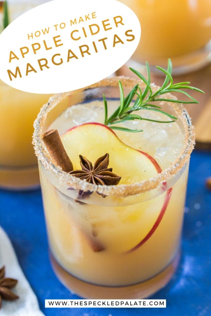 Close up of an Apple Cider Margarita garnished with an apple slice, star anise, cinnamon stick and rosemary with the text 'how to make apple cider margaritas'