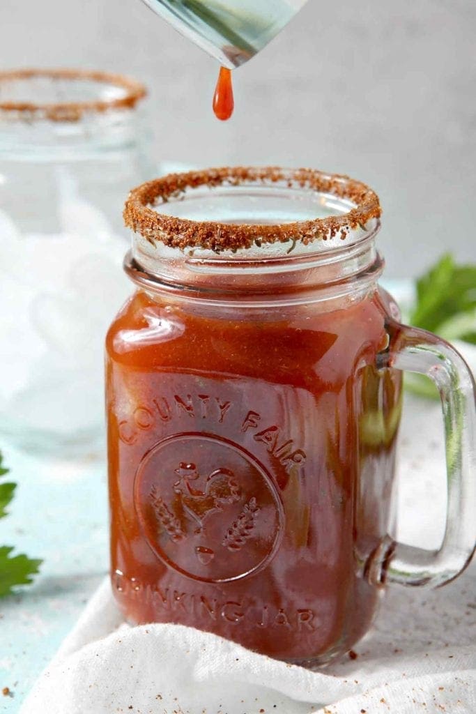 A BBQ Bloody Mary is poured into a prepped glass