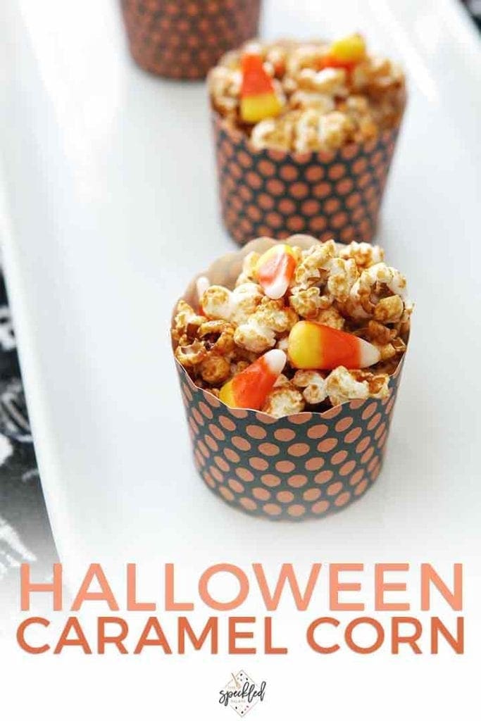 Black and orange paper bowls hold servings of caramel corn with candy corn on a white platter with the text halloween caramel corn