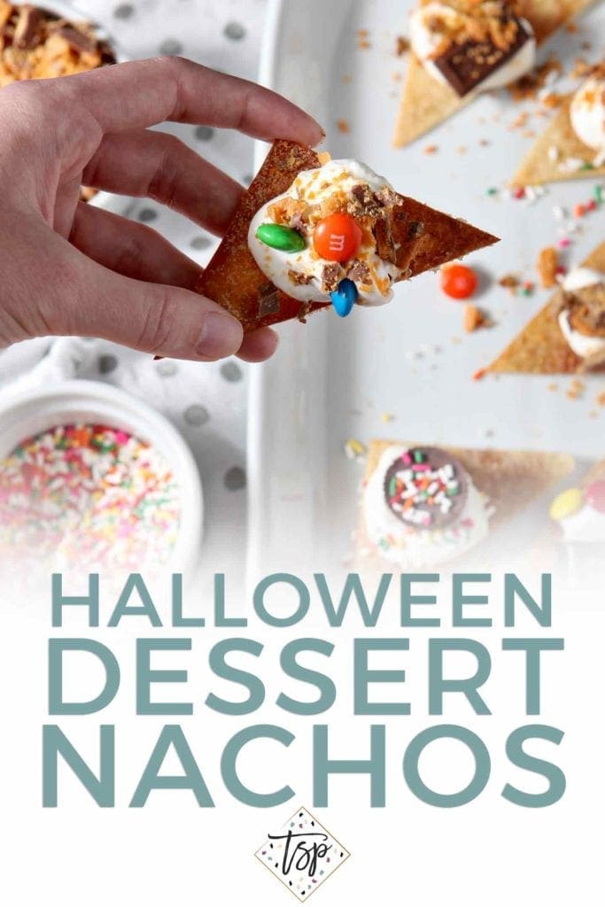 Pinterest image for Halloween Dessert Nachos, featuring a woman holding an individual nacho from above with Pinterest text