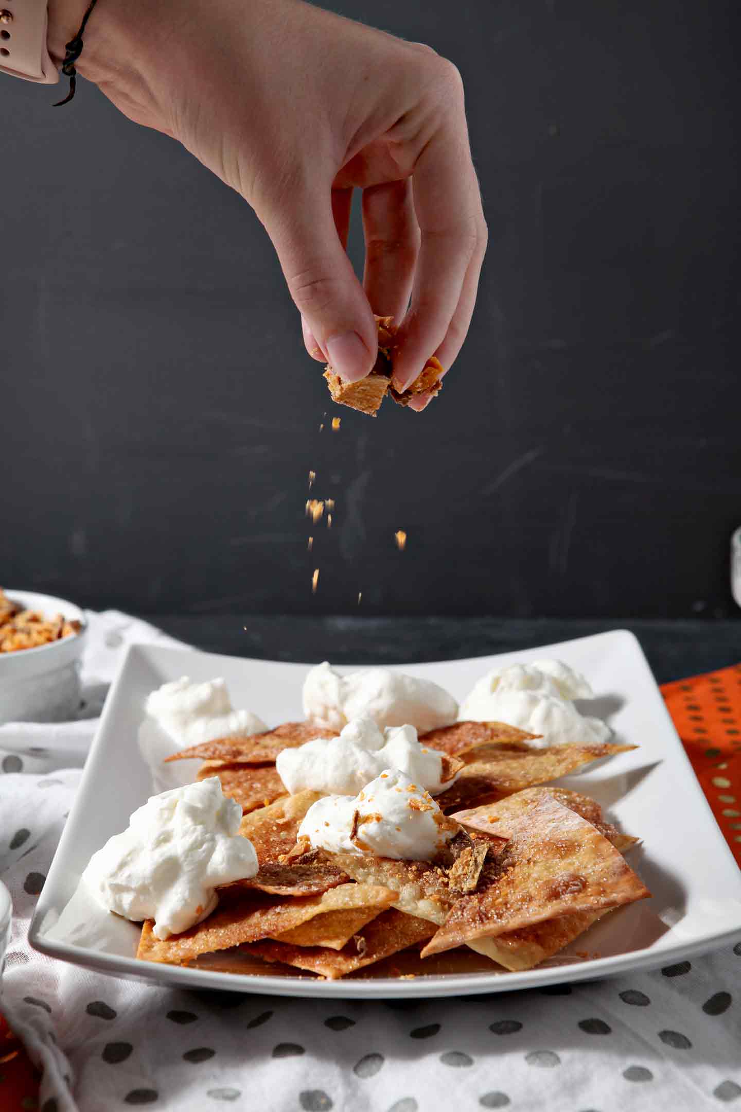 Butterfingers are sprinkled on top of a platter of Halloween Dessert Nachos