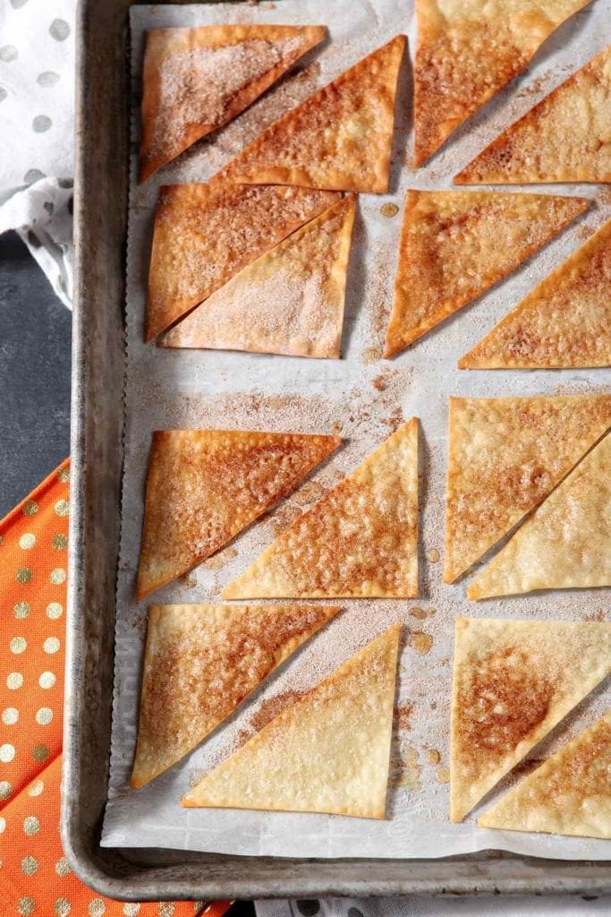 Cinnamon-Sugar Wonton Chips line a baking sheet after baking.