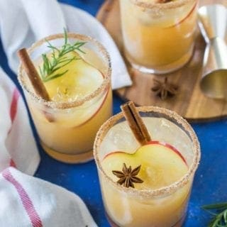 Three Apple Cider Margaritas sit on a blue background