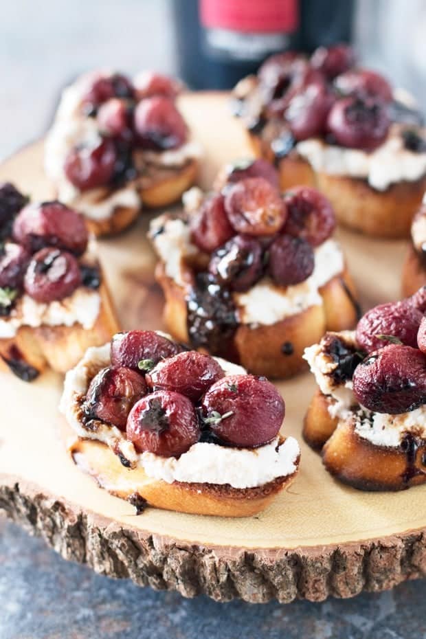 Roasted Grape Balsamic Crostini are served on a wooden board