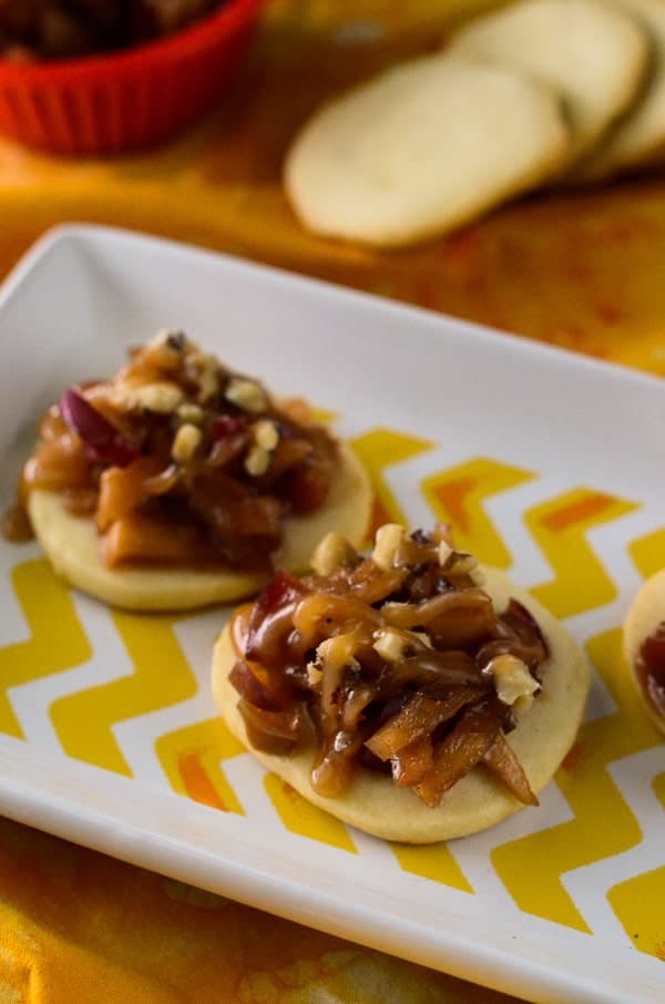 A yellow and white chevron plate holds Caramel Apple Shortbread Bruschetta