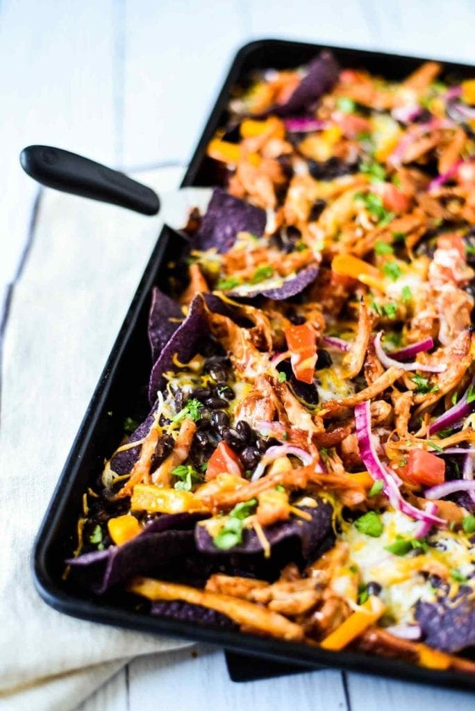 Close up of a colorful tray of Sheet Pan BBQ Chicken Nachos