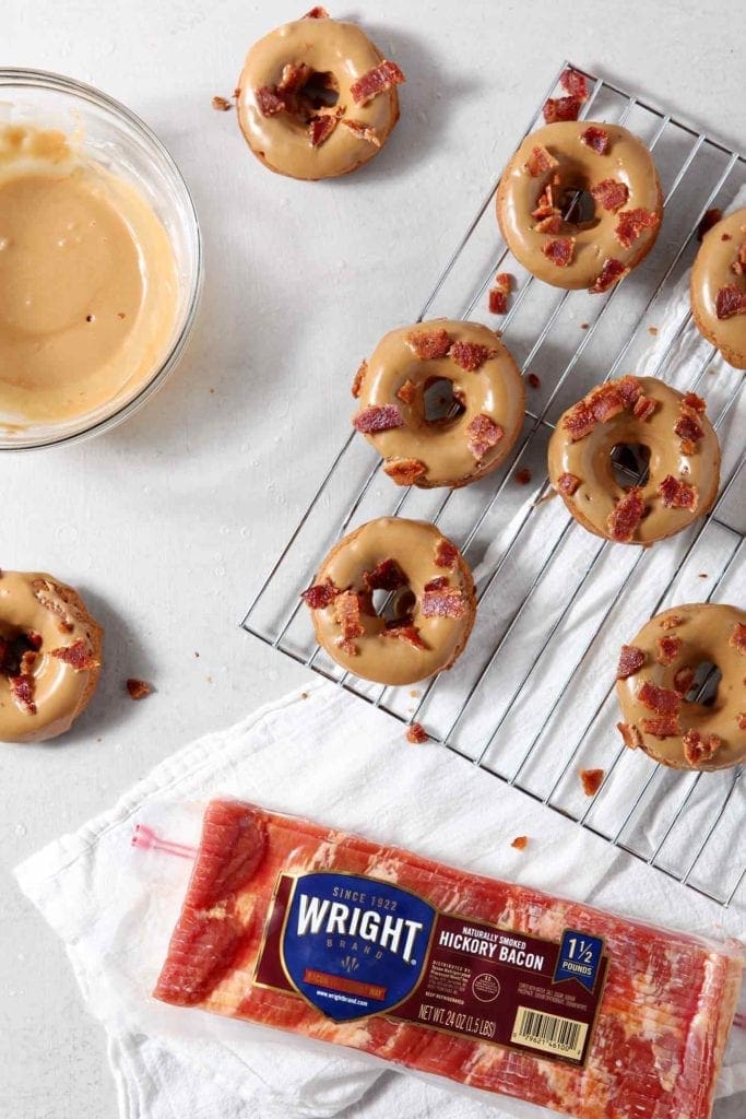 Maple Bacon Donuts with maple icing and bacon crumbles cool on a wire rack