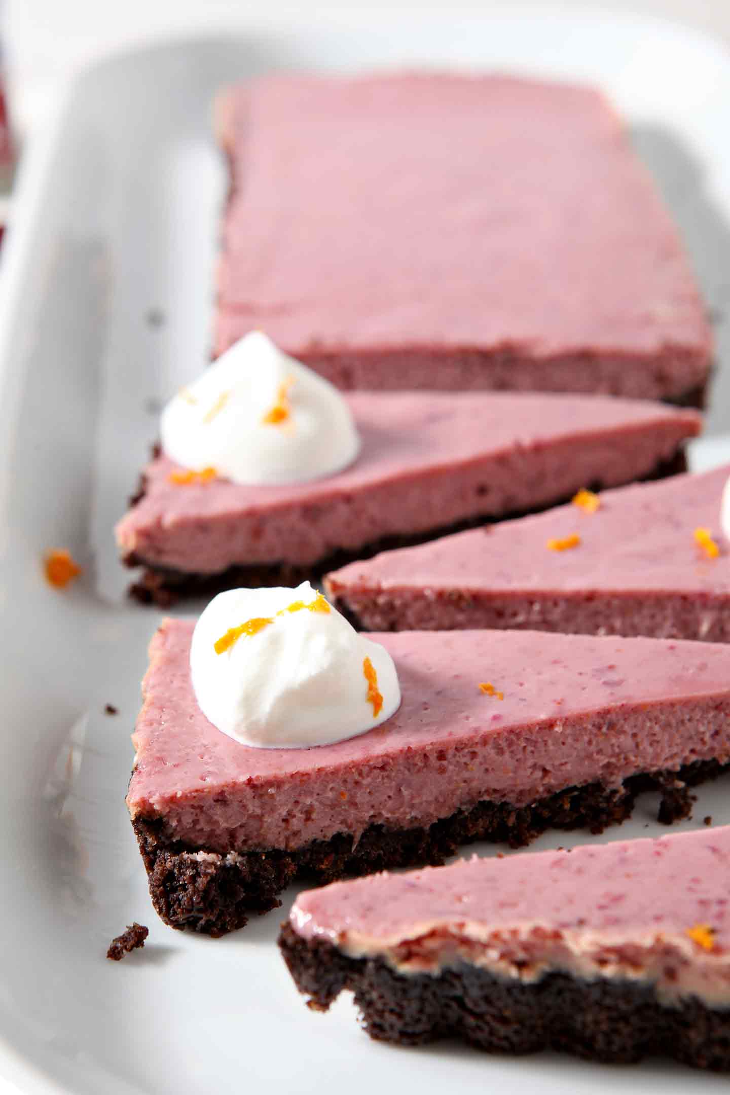 Close up of slices of Creamy Cranberry Tart, topped with fresh whipped cream