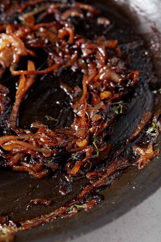 Caramelized onions are shown in a pan before going into the refrigerator to cool for French Onion Biscuits